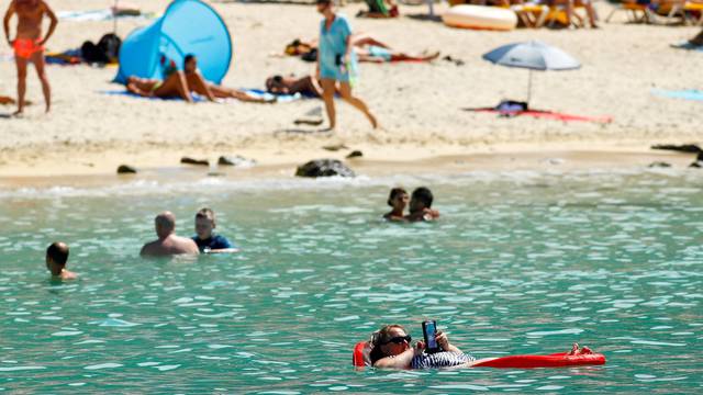 FILE PHOTO: A tourist sunbathes