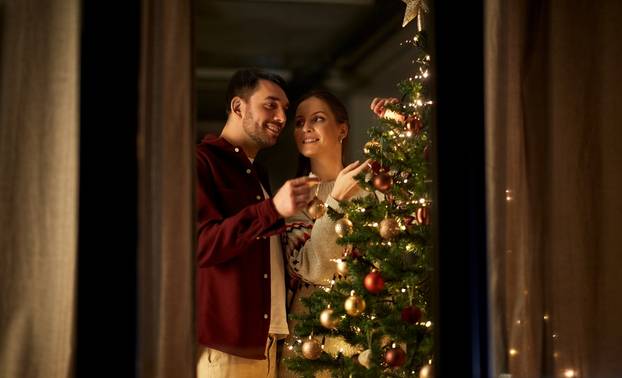 Winter,Holidays,And,People,Concept,-,Happy,Couple,Decorating,Christmas