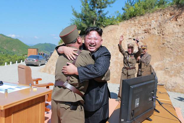 North Korean leader Kim Jong Un reacts with scientists and technicians of the DPRK Academy of Defence Science after the test-launch of Hwasong-14 in this undated photo released by KCNA
