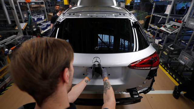 An employee of German car manufacturer Mercedes Benz installs the characteristic "Mercedes star" at a A-class model at the production line at the Daimler factory in Rastatt