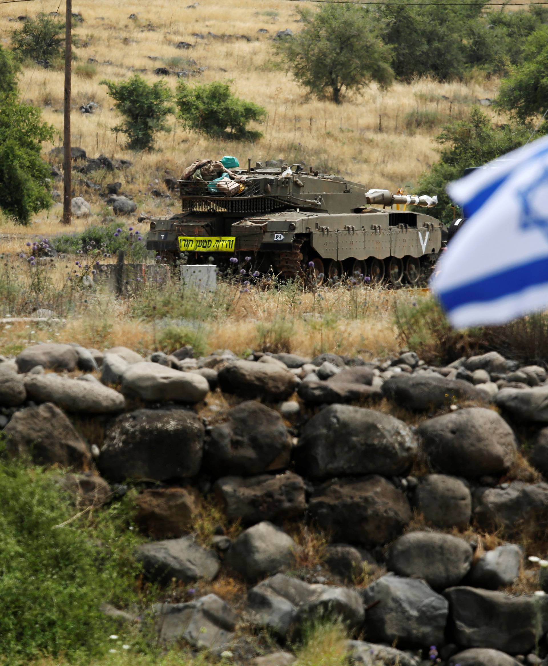 An Israeli tank can be seen near the Israeli side of the border with Syria in the Israeli-occupied Golan Heights