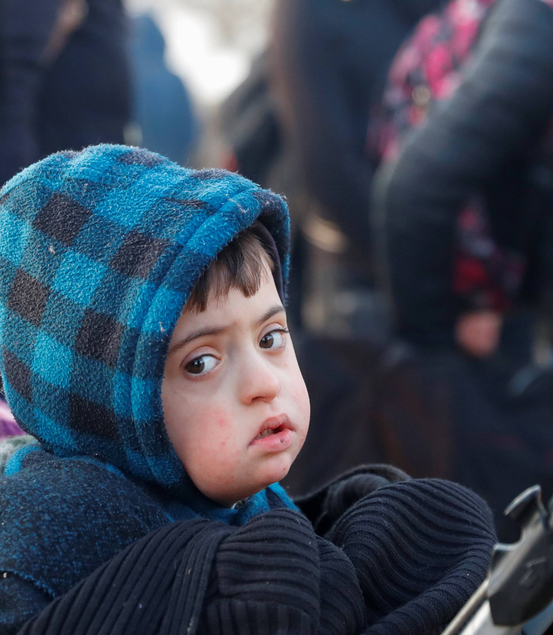 A child is pictured as migrants rest next to the Turkey's Pazarkule border crossing with Greece's Kastanies, near Edirne