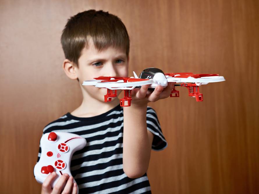 Little boy with toy quadcopter drone