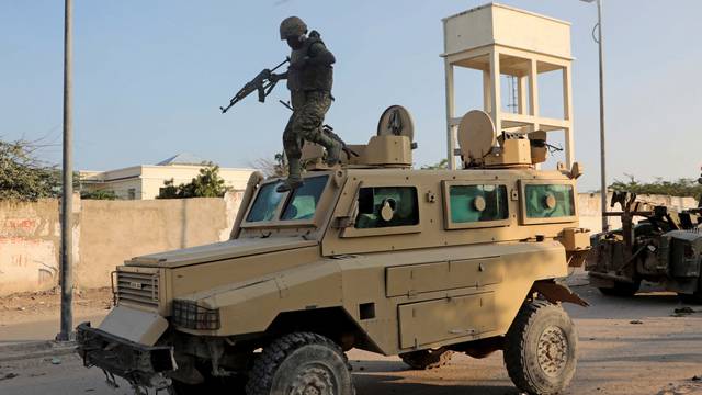 FILE PHOTO: A soldier serving in the African Union Mission in Somalia (AMISOM) jumps off a military vehicle near the scene of a suicide explosion targeting the AMISOM convoy in Mogadishu