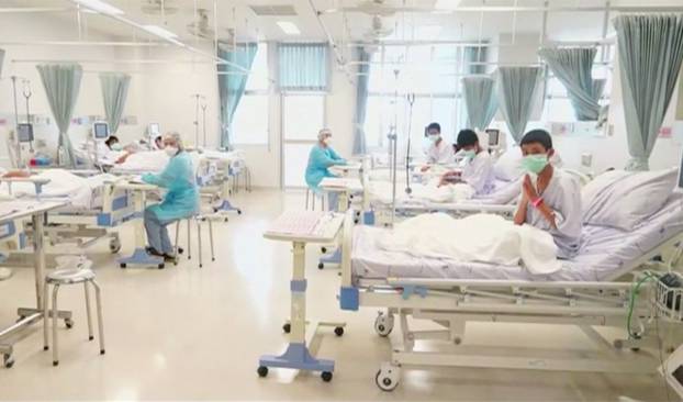 Boys rescued from the Thai cave wear masks and rest at a hospital in Chiang Rai