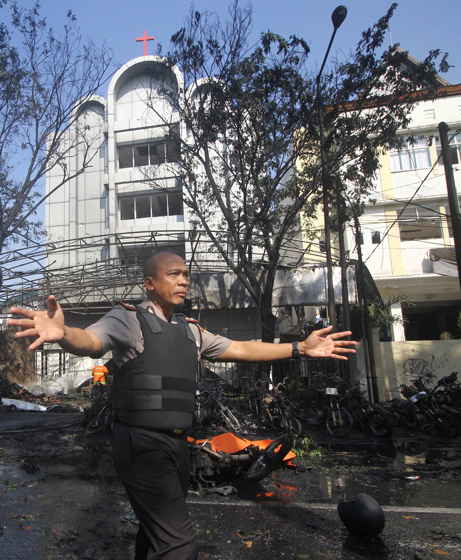 Police stand guard near the site of a blast at the Pentecost Church Central Surabaya (GPPS), in Surabaya, East Java,