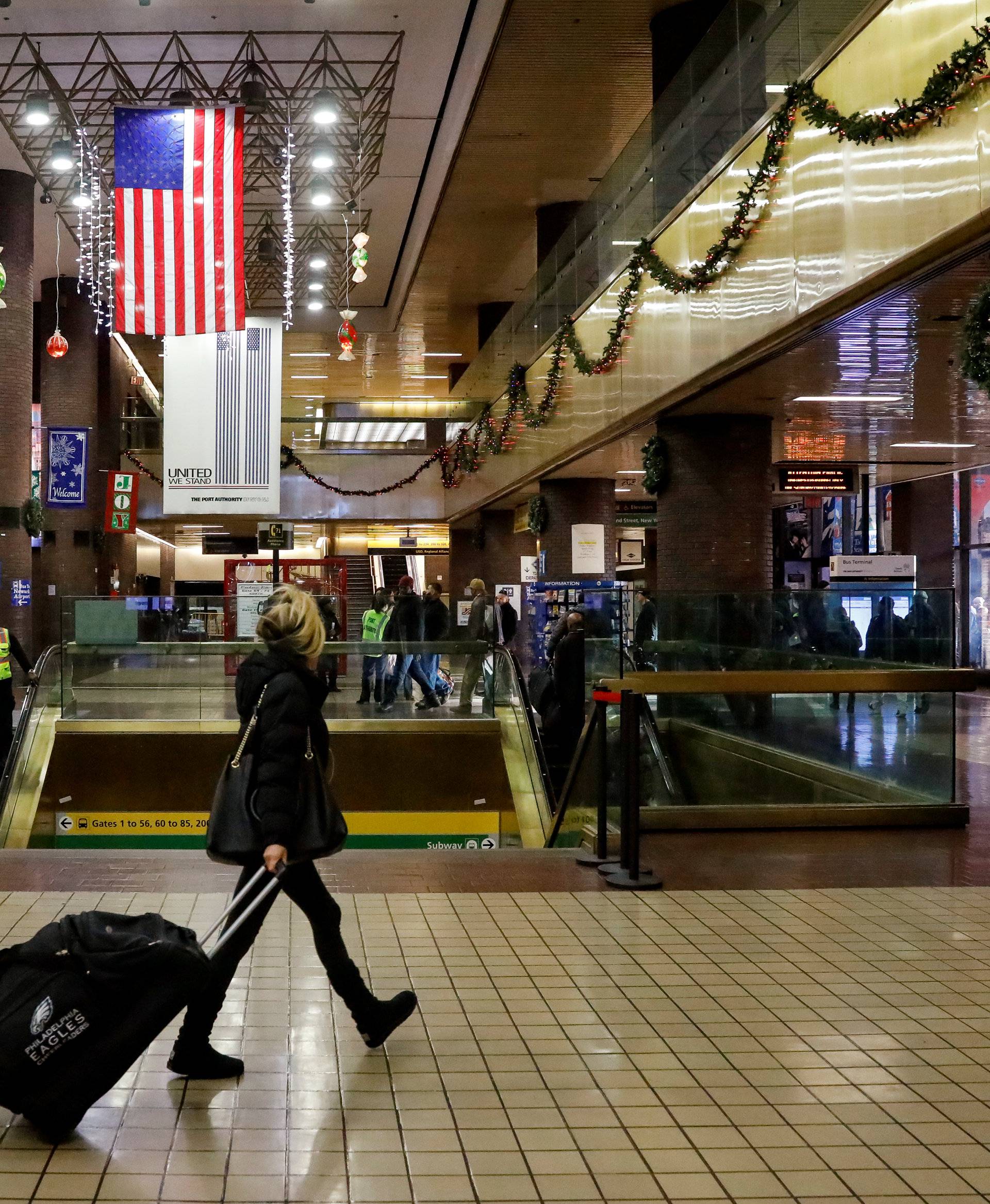 A woman walks through the New York Port Authority bus terminal following an attempted detonation during the morning rush hour in New York