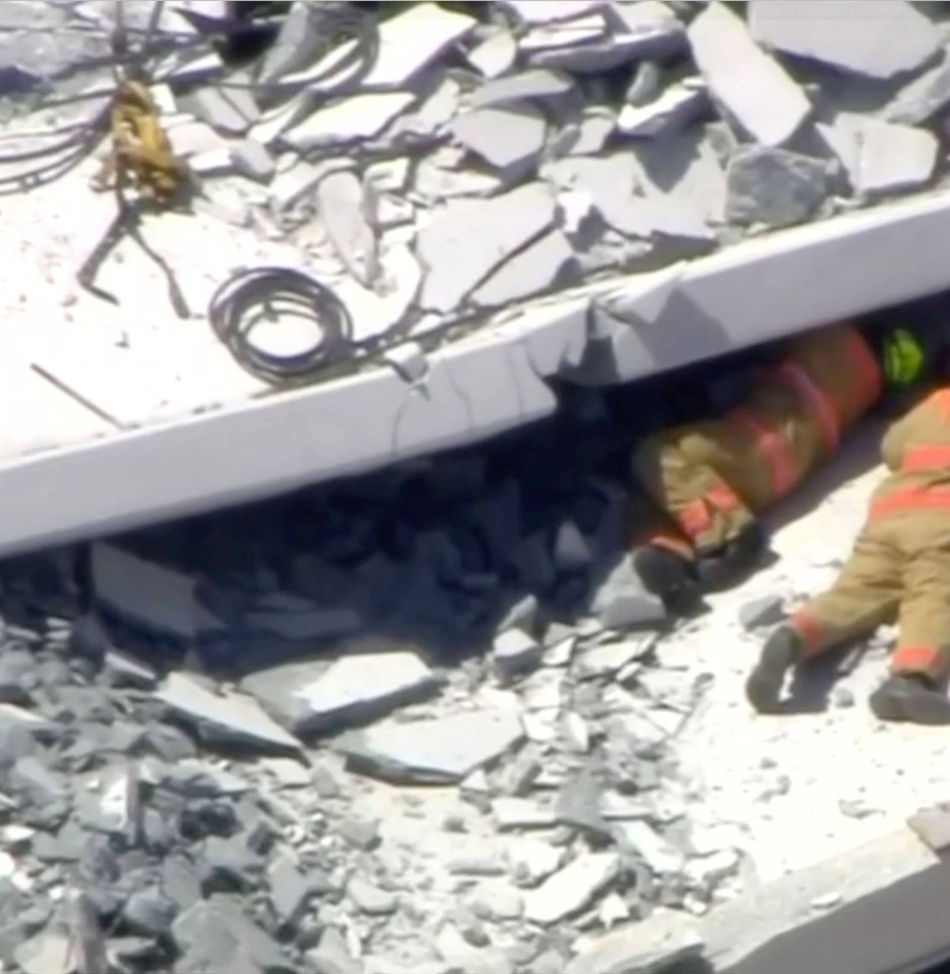 Emergency crews look for victims at the scene of a collapsed pedestrian bridge at Florida International University in Miami, Florida