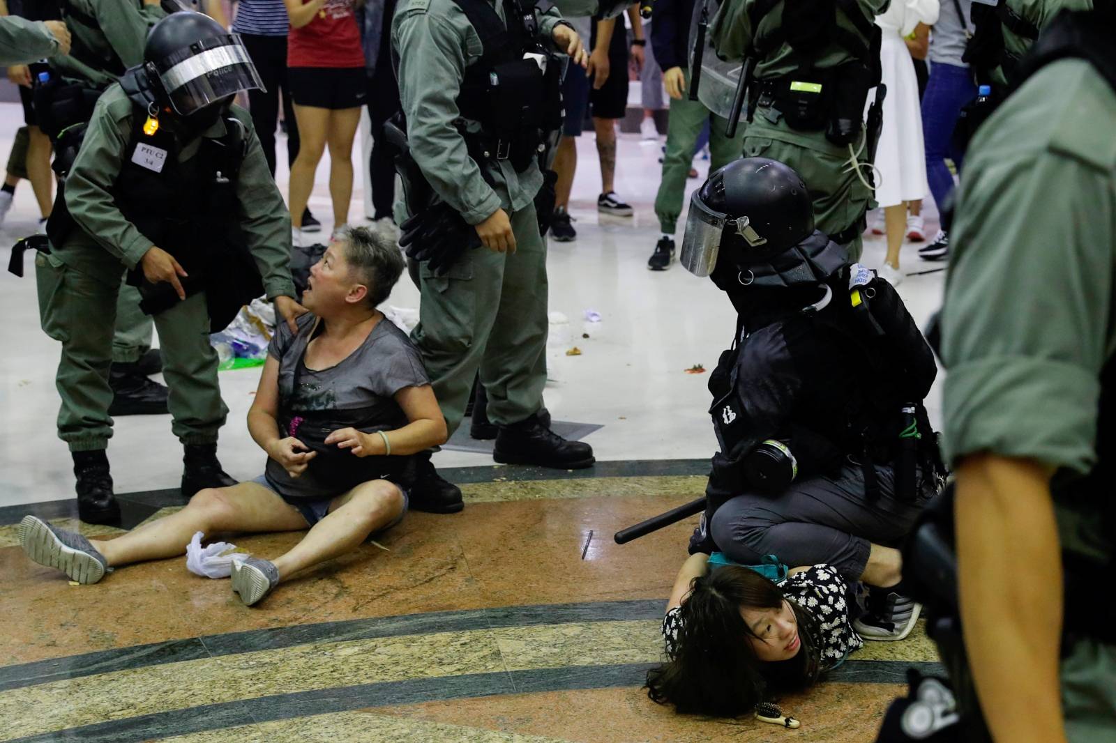 Riot police detain anti-government protesters at a shopping mall in Tai Po, Hong Kong