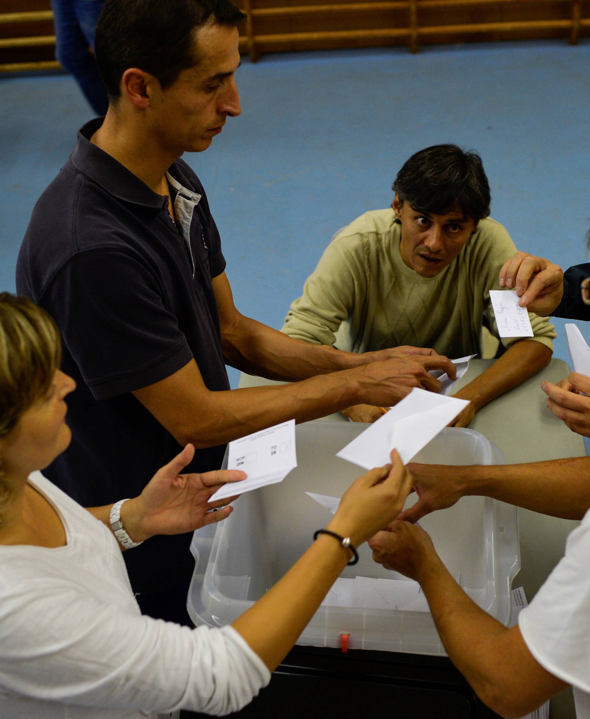 Poll workers count ballots after polls closed in the banned independence referendum in Vic