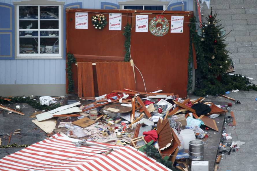 A christmas tree stands beside remains of a wooden christmas booth at the Christmas market in Berlin