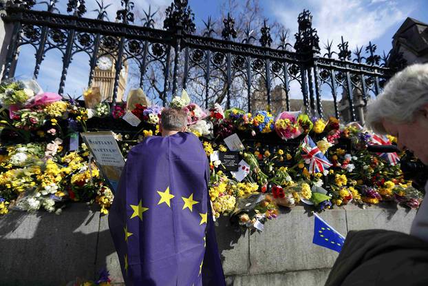 Floral tributes are seen at the fence surrounding the House of Parliament, following the attack in Westminster earlier in the week, in London