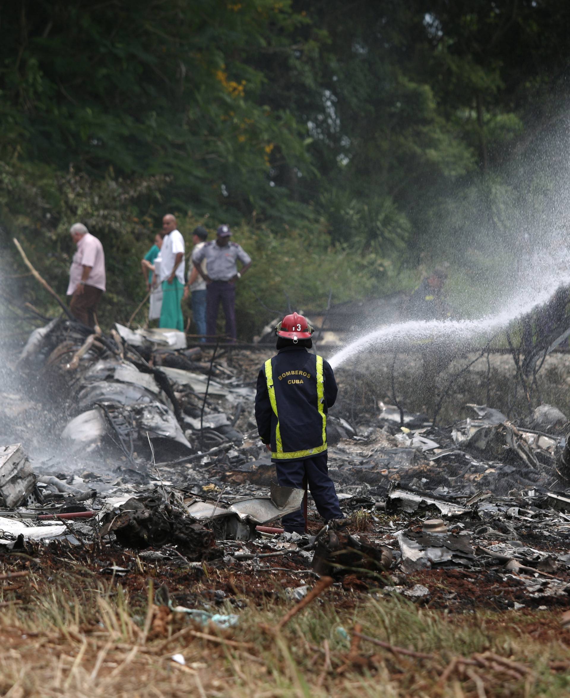 A fire fighter works in the wreckage of a Boeing 737 plane that crashed  in the agricultural area of Boyeros, some 20 km (12 miles) south of Havana on Friday shortly after taking off from Havana's main airport in Cuba
