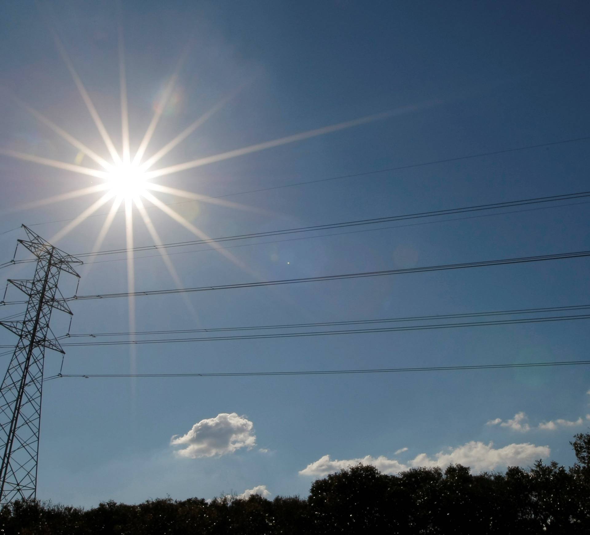 FILE PHOTO: Sun shines over a high tension power line in an industrial area of Sydney