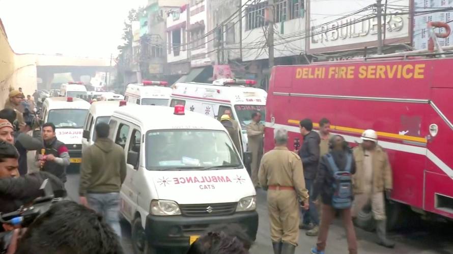 Video grab of ambulences and a firefighting vehicle at the scene of a deadly fire that swept through a factory where laborers were sleeping, in New Delhi