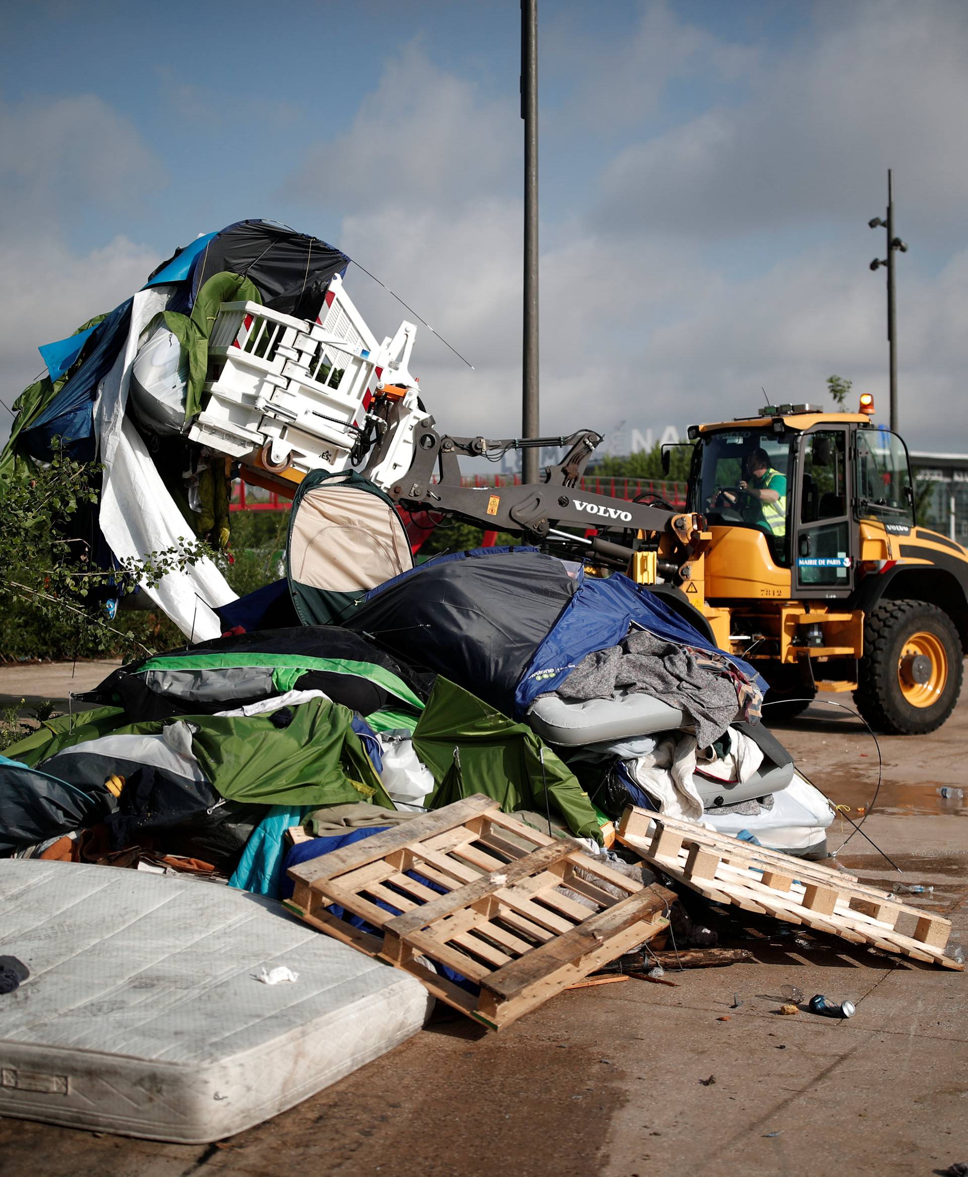 A makeshift camp is cleared away as French police evacuate hundreds of migrants living in tents along a canal in Paris