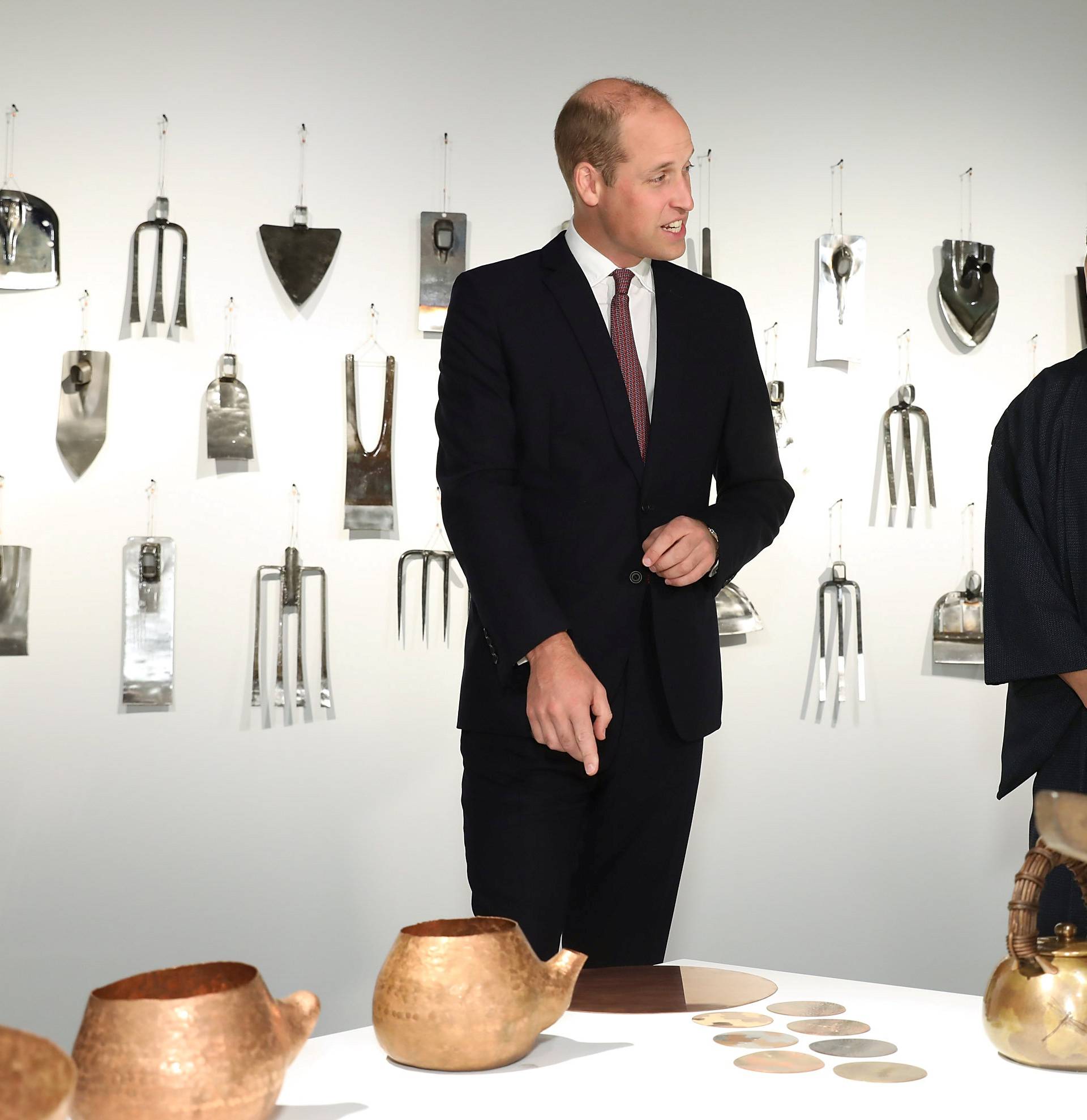 Britain's Prince William talks with Motoyuki Tamagawa, Head of Copperwear Workshop, at the official opening of Japan House in London