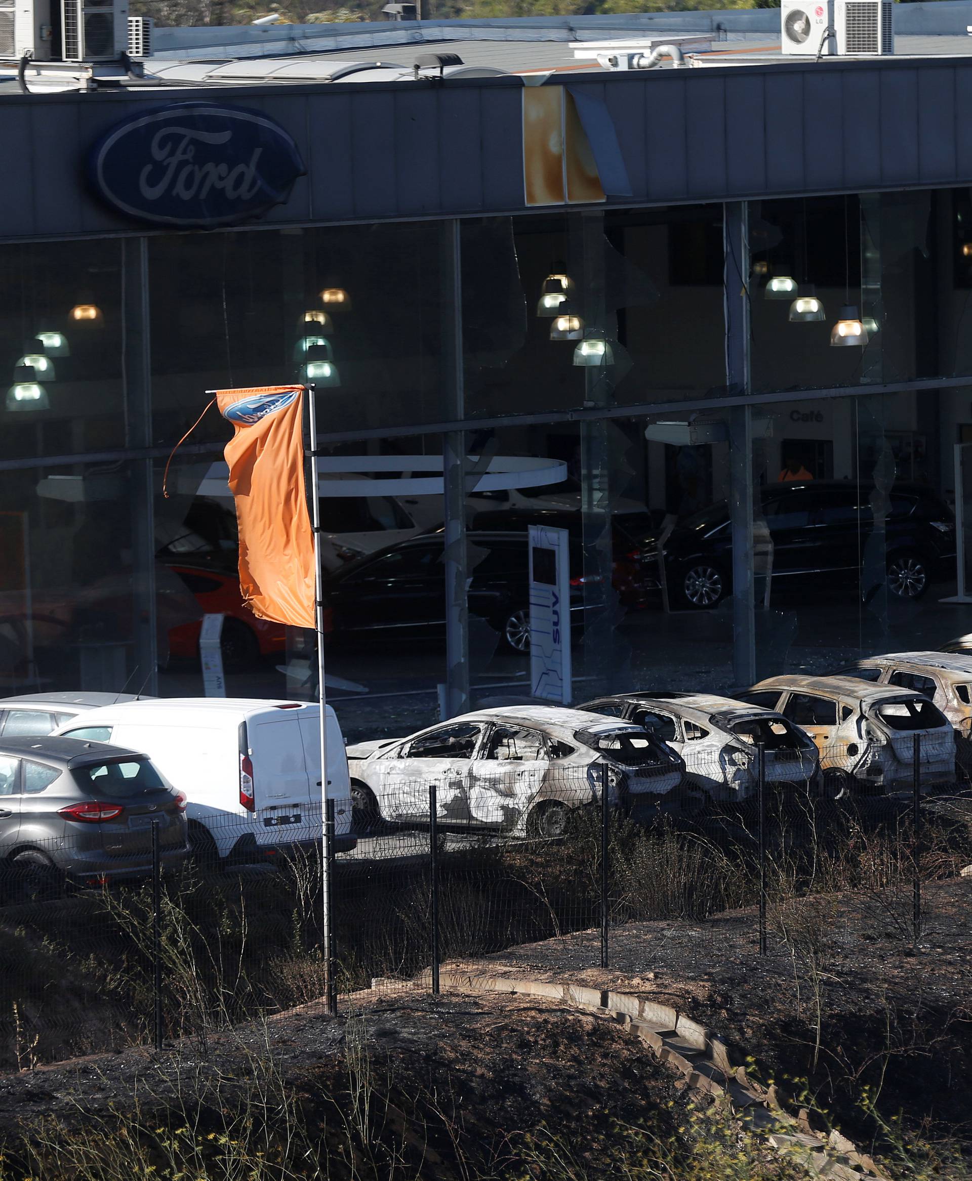 Destroyed cars are seen outside an automobile dealership in Vitrolles the day after fires, fanned by strong northern winds known as the mistral, ravaged more than 2,000 hectares of the dry, pine-planted hills north of Marseille