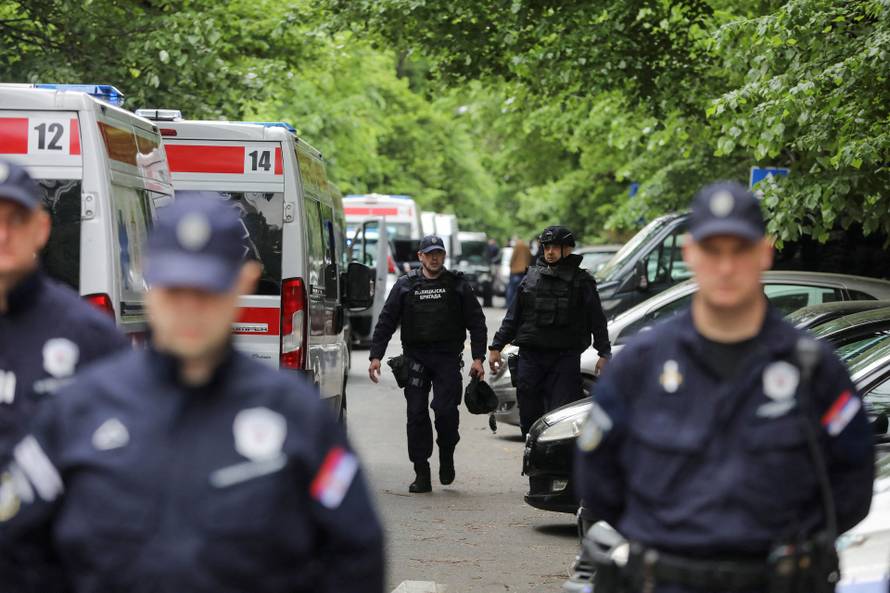 Police officers secure the area after a 14-year-old boy opened fire on other students and security guards at a school in downtown Belgrade