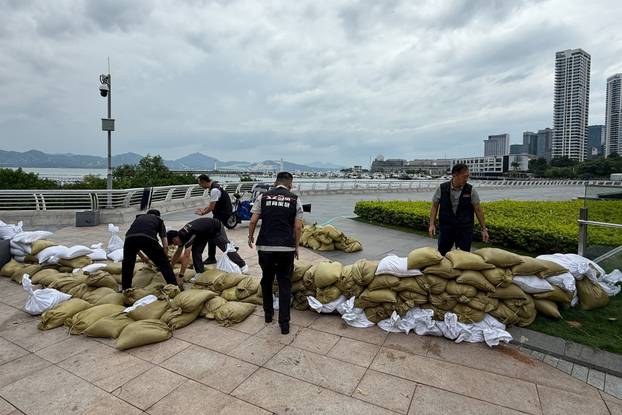 Emergency team members place sandbags at the Shekou waterfront as Super Typhoon Ragasa approaches, in Shenzhen