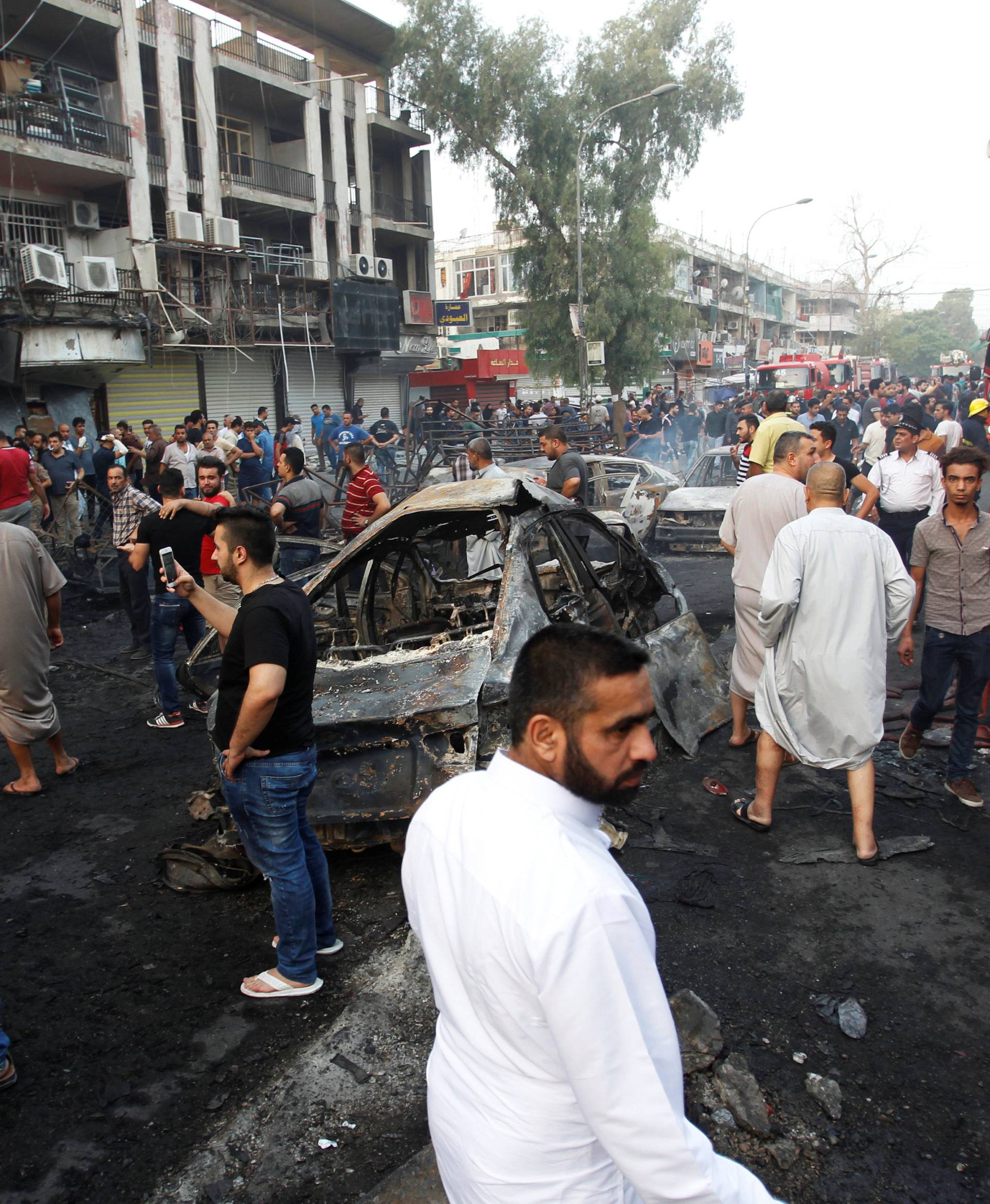 People gather at the site of a suicide car bomb in the Karrada shopping area, in Baghdad, Iraq 