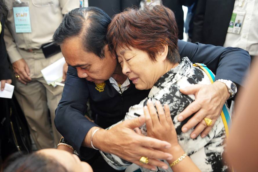 Thailand's Prime Minister Prayuth Chan-ocha comforts a relative of Chinese tourists involved in a sunken tourist boat accident at a hospital in Phuket