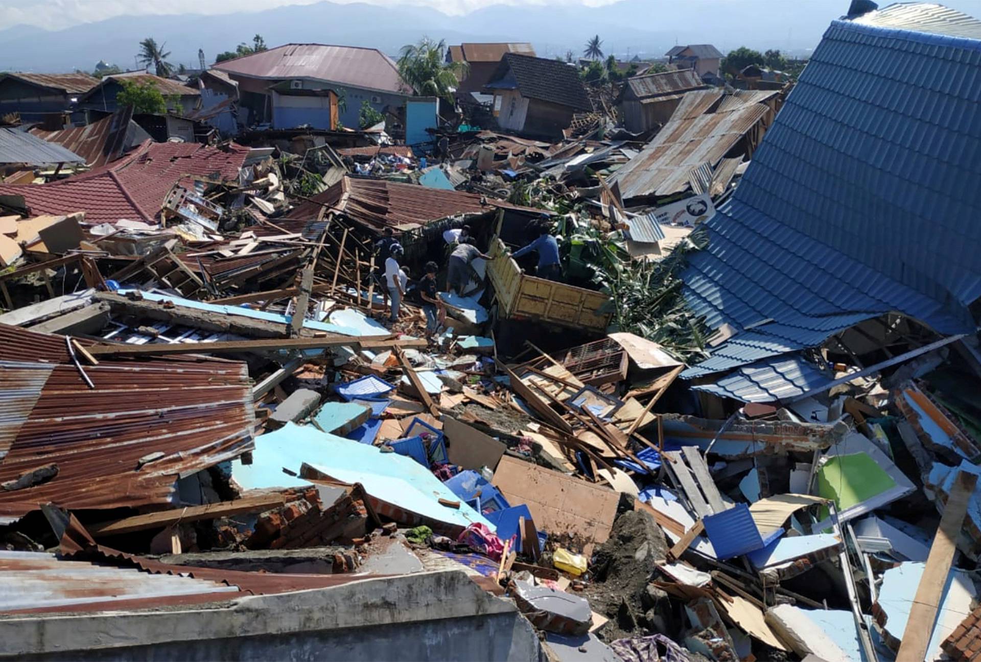 People search through debris in a residential area following an earthquake and tsunami in Palu