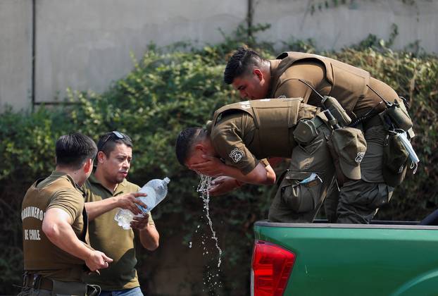 Police officers drink water and refresh themselves amid the spread of wildfires in Vina del Mar