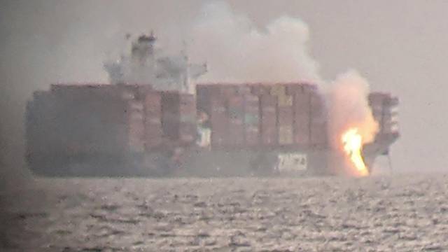 Fire cascades down from the deck of the container ship ZIM Kingston into the waters off the coast of Victoria, British Columbia, Canada