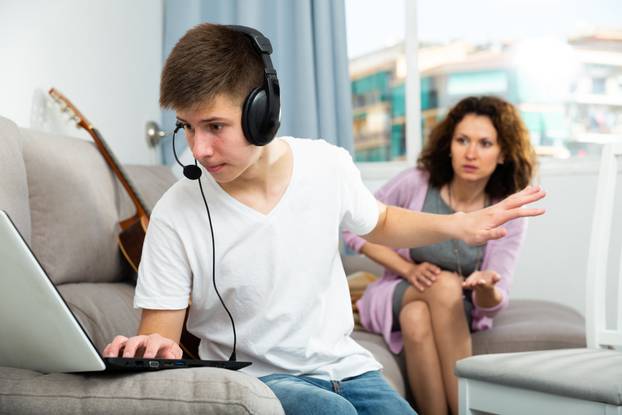 Portrait,Of,Teenager,Boy,Addicted,With,Laptop,Not,Listening,Mother