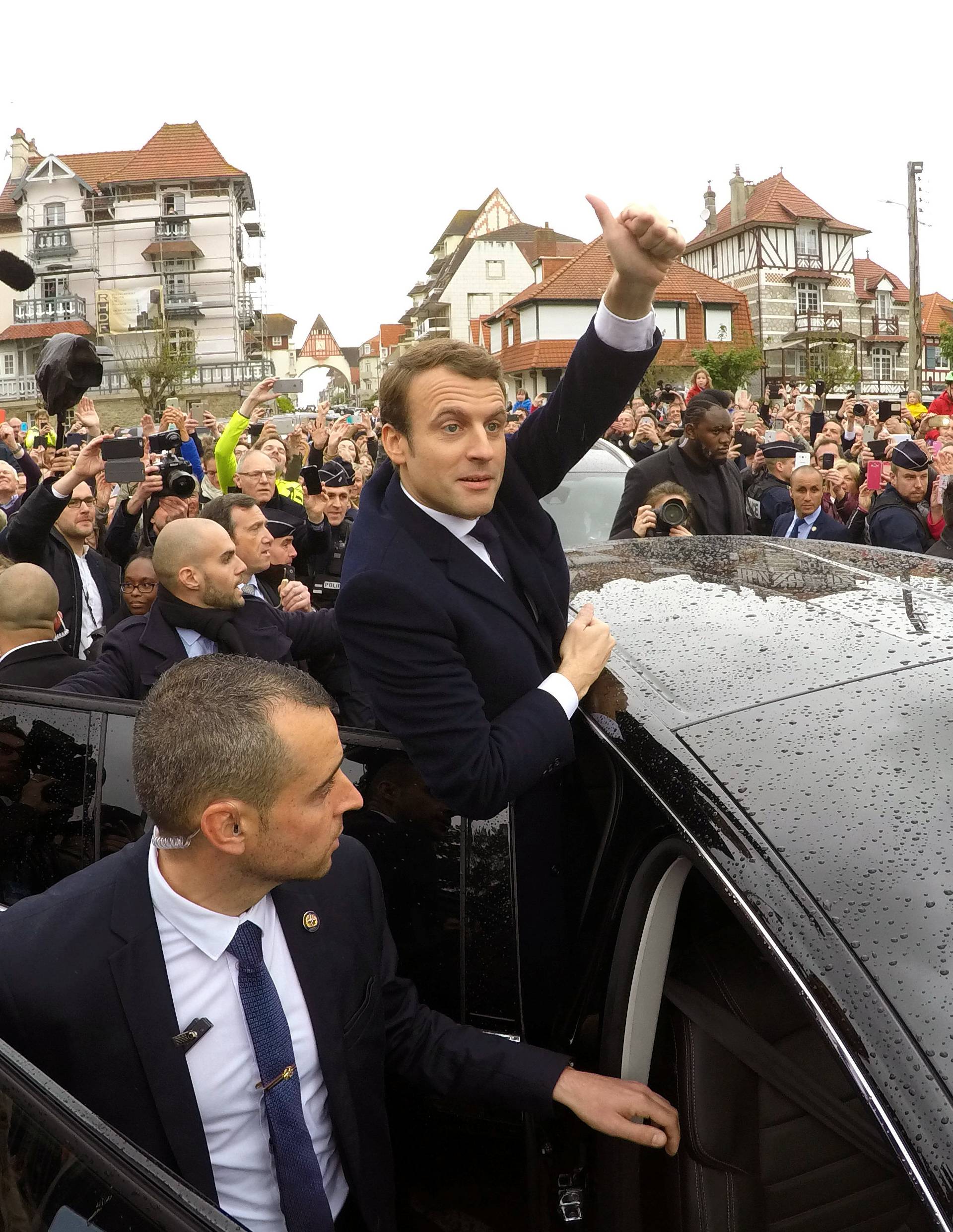 French presidential election candidate Emmanuel Macron greets supporters as he leaves a polling station during the the second round of 2017 French presidential election, in Le Touquet