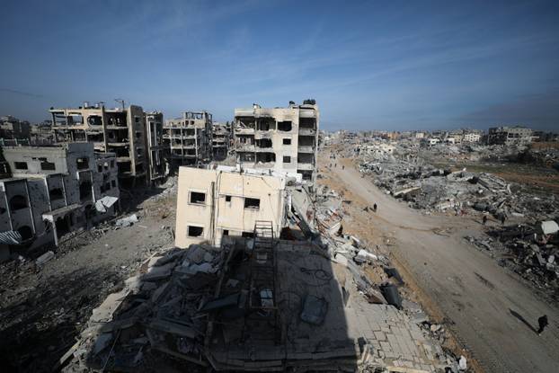 Displaced Palestinians walk past the rubble as they attempt to return to their homes, in the northern Gaza Strip