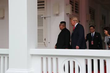 U.S. President Donald Trump walks with North Korean leader Kim Jong Un at the Capella Hotel on Sentosa island in Singapore