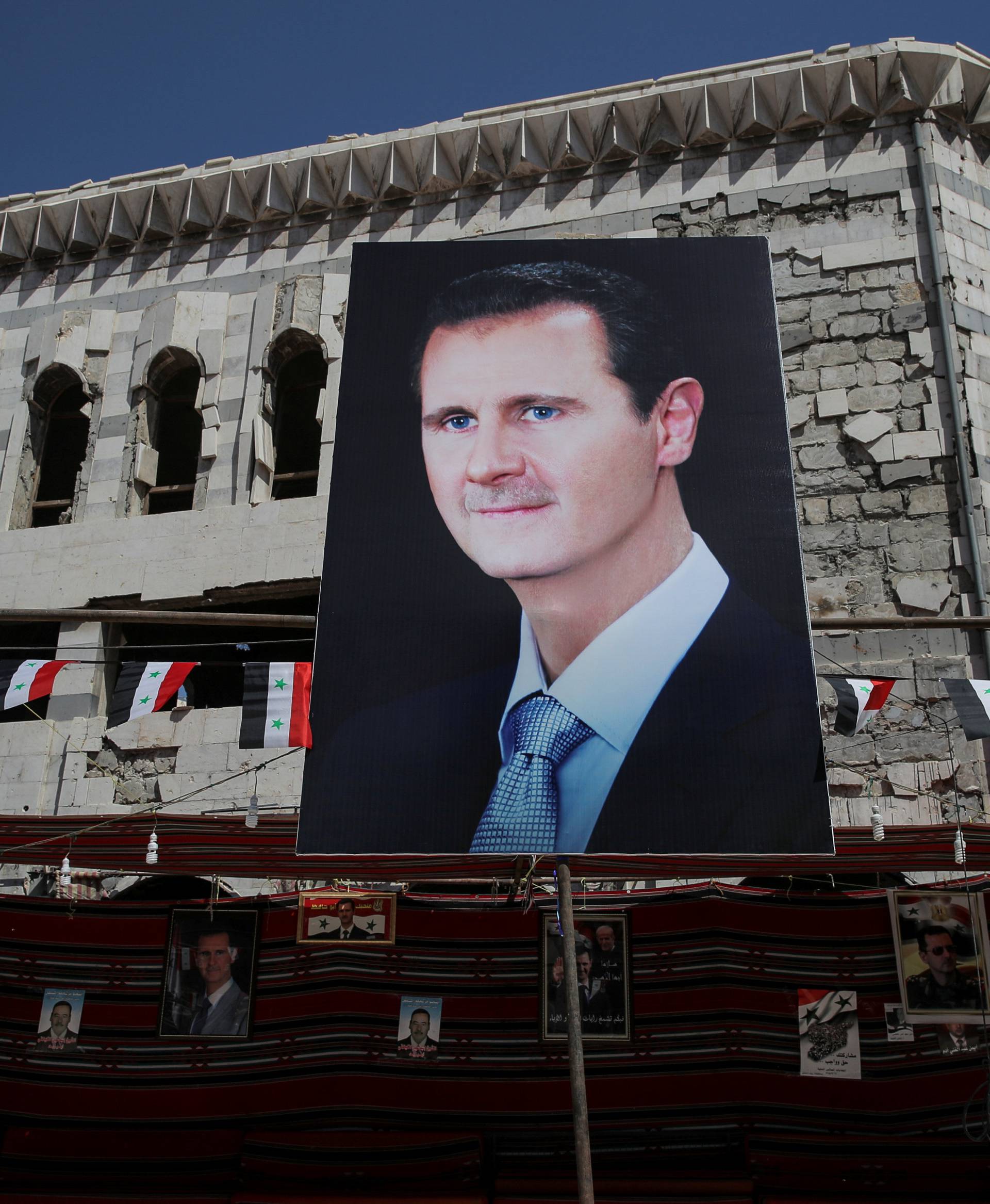 FILE PHOTO: A banner depicting Syrian President Bashar al-Assad in Douma, outside Damascus, Syria