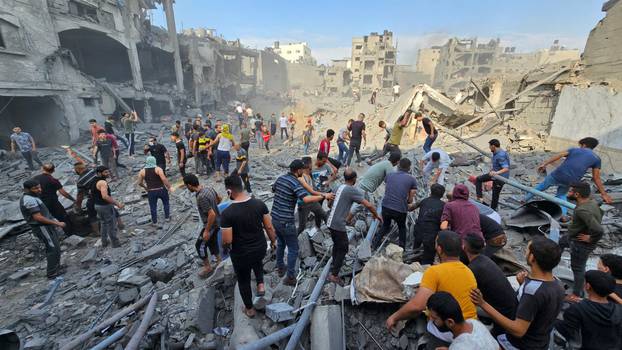 Palestinians search for casualties at the site of Israeli strikes on houses in Jabalia refugee camp