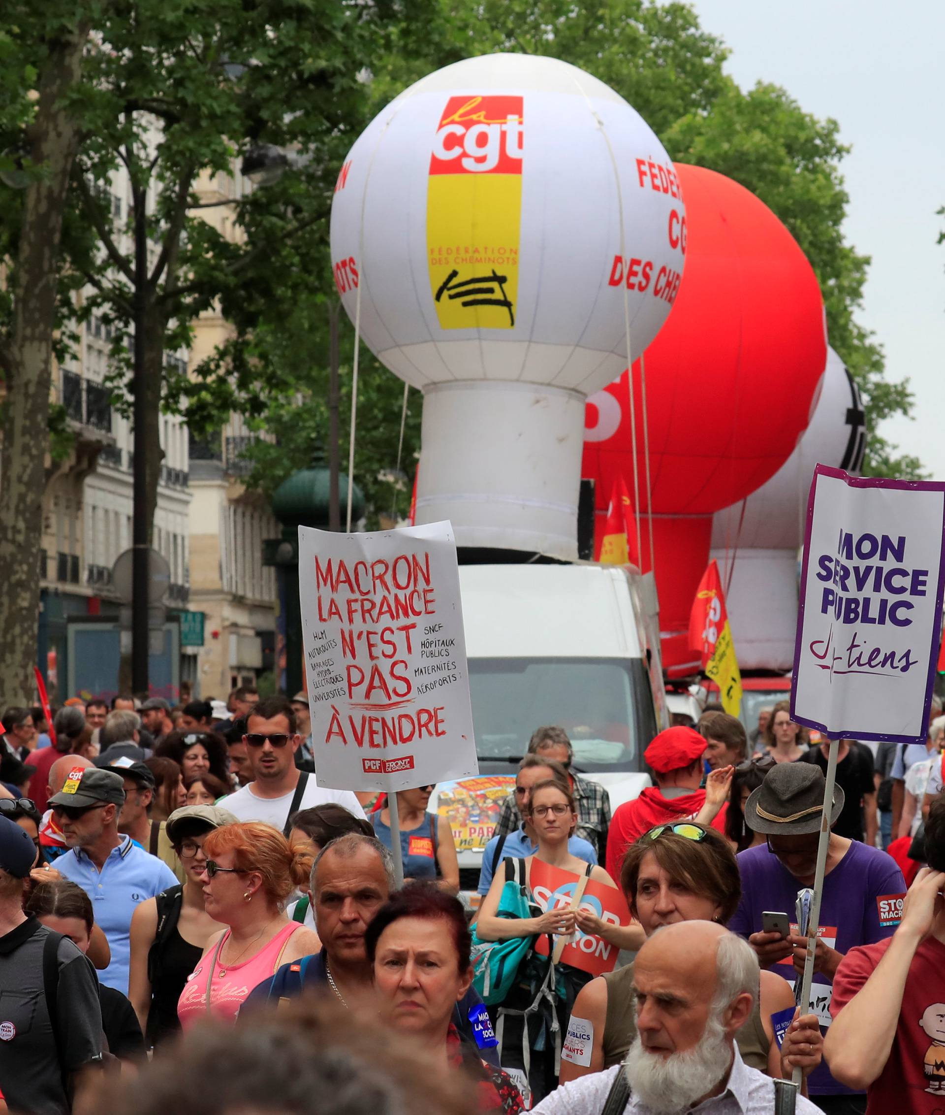 Protesters hold placards during a demonstration by French unions and France Insoumise" (France Unbowed) political party to protest against government reforms, in Paris