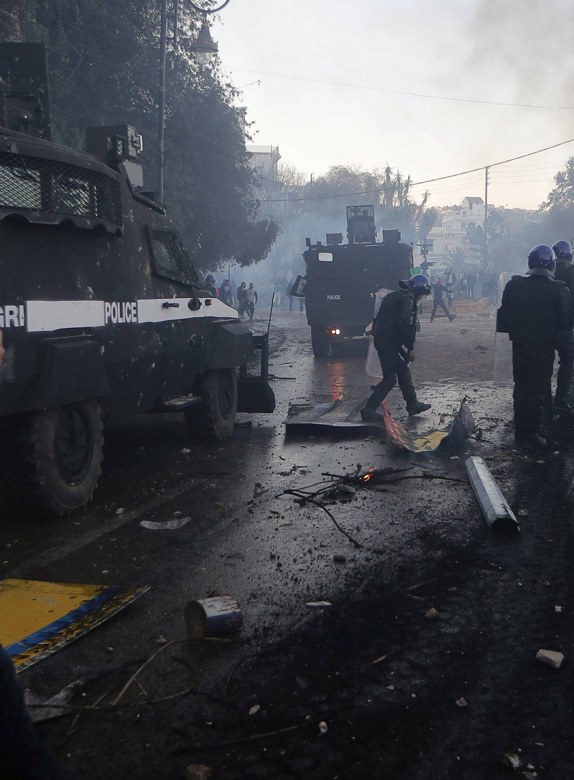 Anti-riot police officers clash with people protesting against President Abdelaziz Bouteflika's plan to extend his 20-year rule by seeking a fifth term in April elections in Algiers