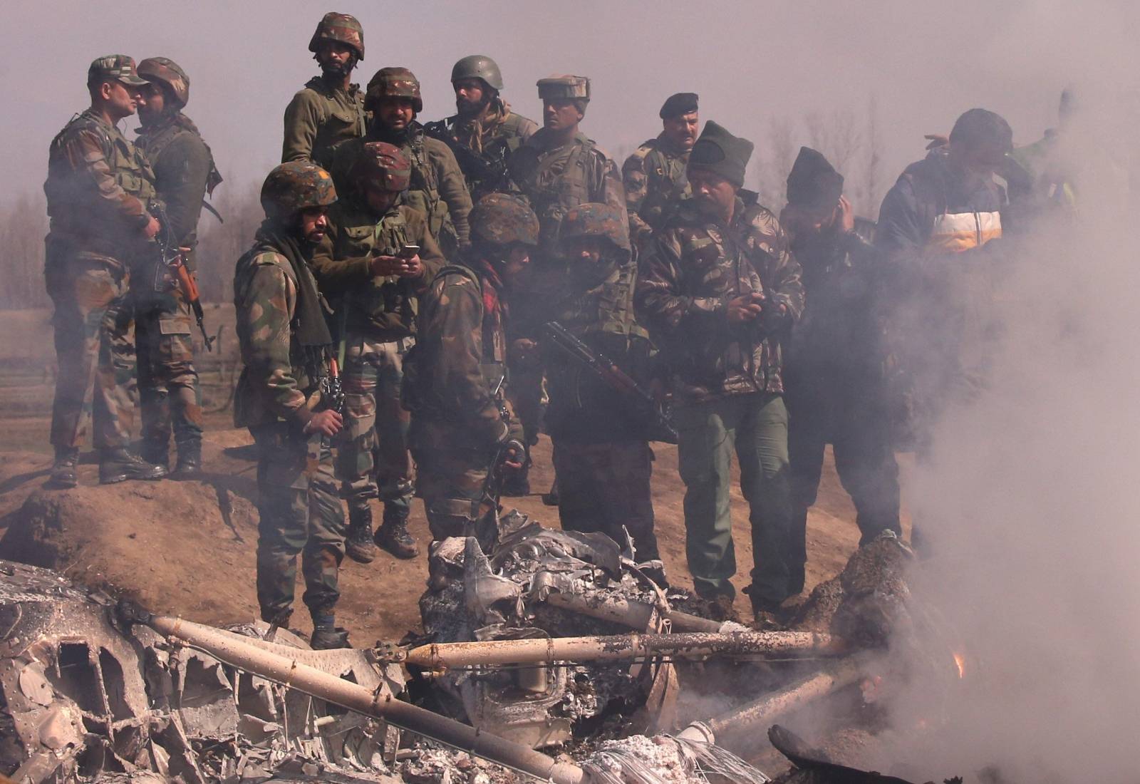 Indian soldiers stand next to the wreckage of Indian Air Force's helicopter after it crashed in Budgam district