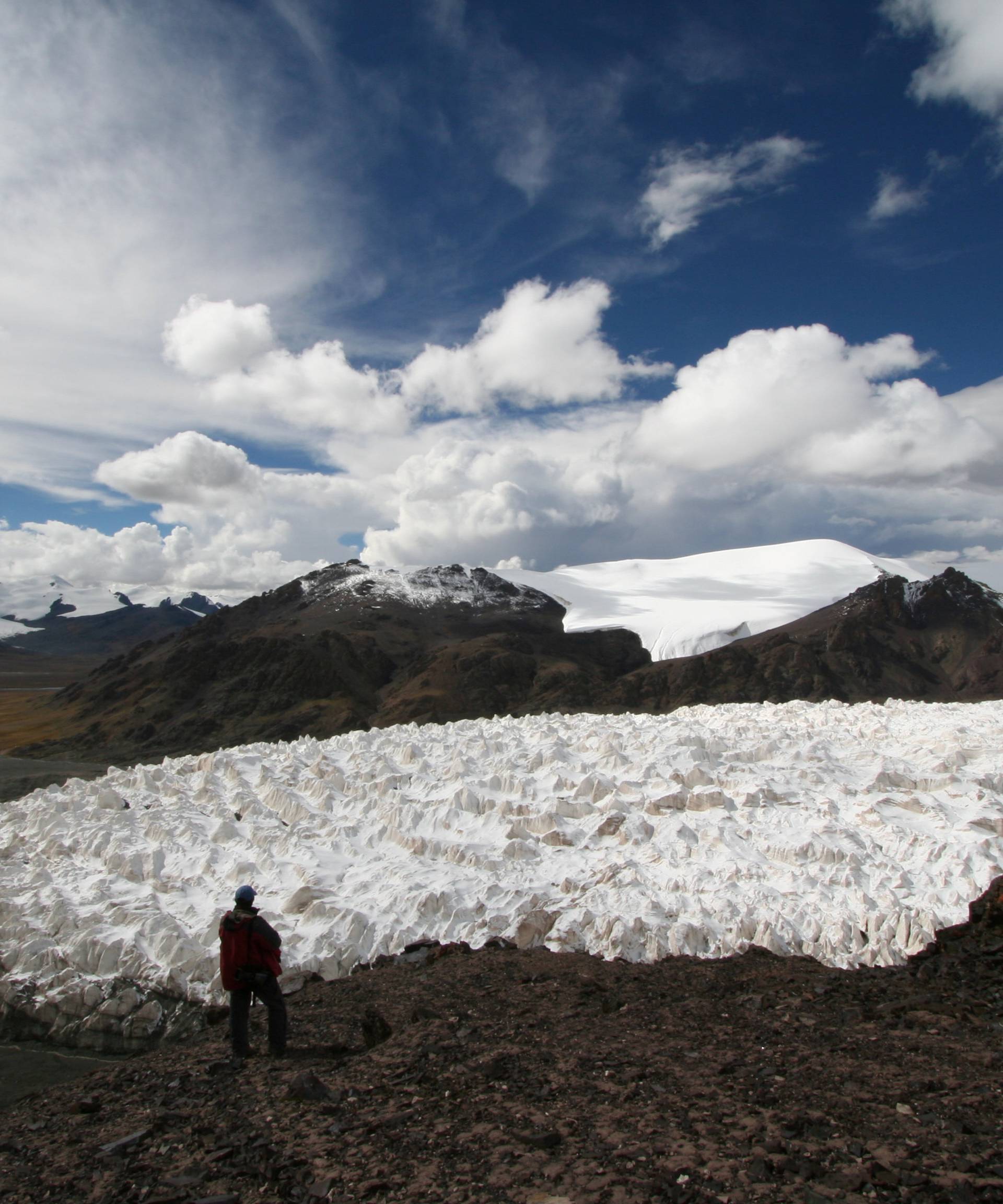 A man stands near the Jianggudiru Glacier on Geladaindong Mountain