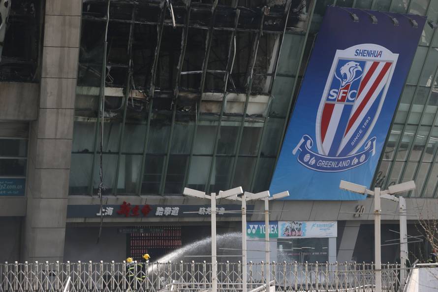 Firefighters are seen outside Hongkou soccer stadium as a fire broke out, in Shanghai