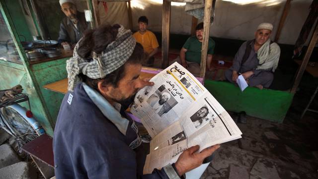 FILE PHOTO: An Afghan man reads a newspaper article on Osama Bin Laden's death, at a roadside tea shop in Kabul