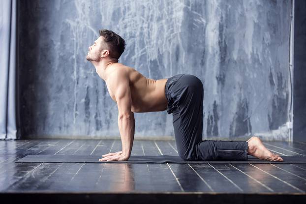 Yoga men workout on black mat.
