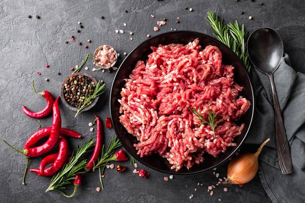 Mince. Ground meat with ingredients for cooking on black background. Top view