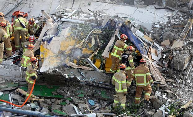 South Korean firefighters search for bus passengers trapped by debris of collapsed building in Gwangju