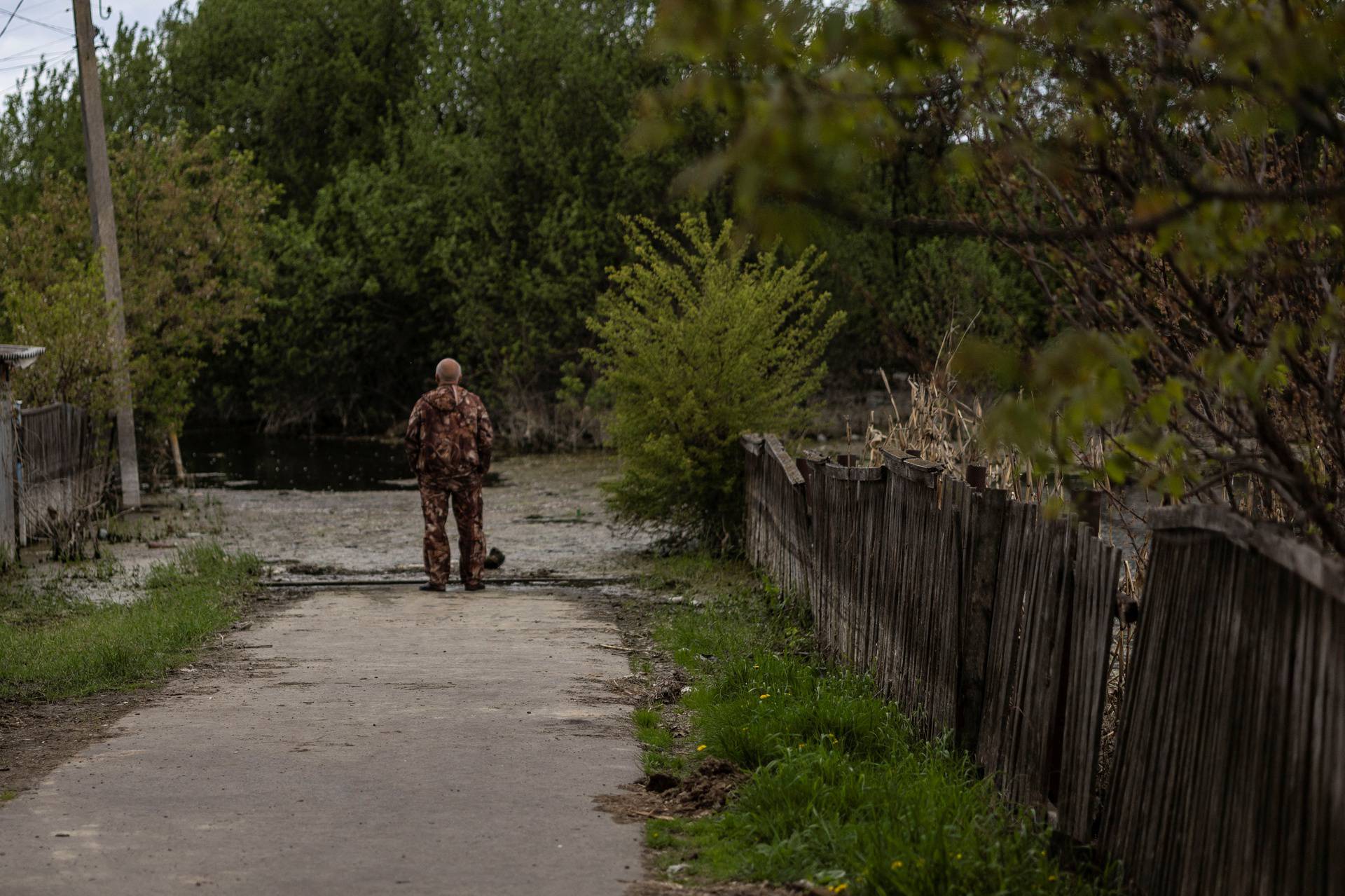 A local resident stands next to a flooded area after Ukrainian military forces opened a dam to flood an residencial area in order to stop advance of Russian forces to arrive to the capital city of Kyiv, in Demydiv, Ukraine,