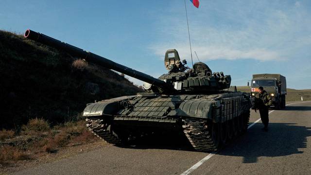FILE PHOTO: A service member of the Russian peacekeeping troops stands next to a tank in Nagorno-Karabakh