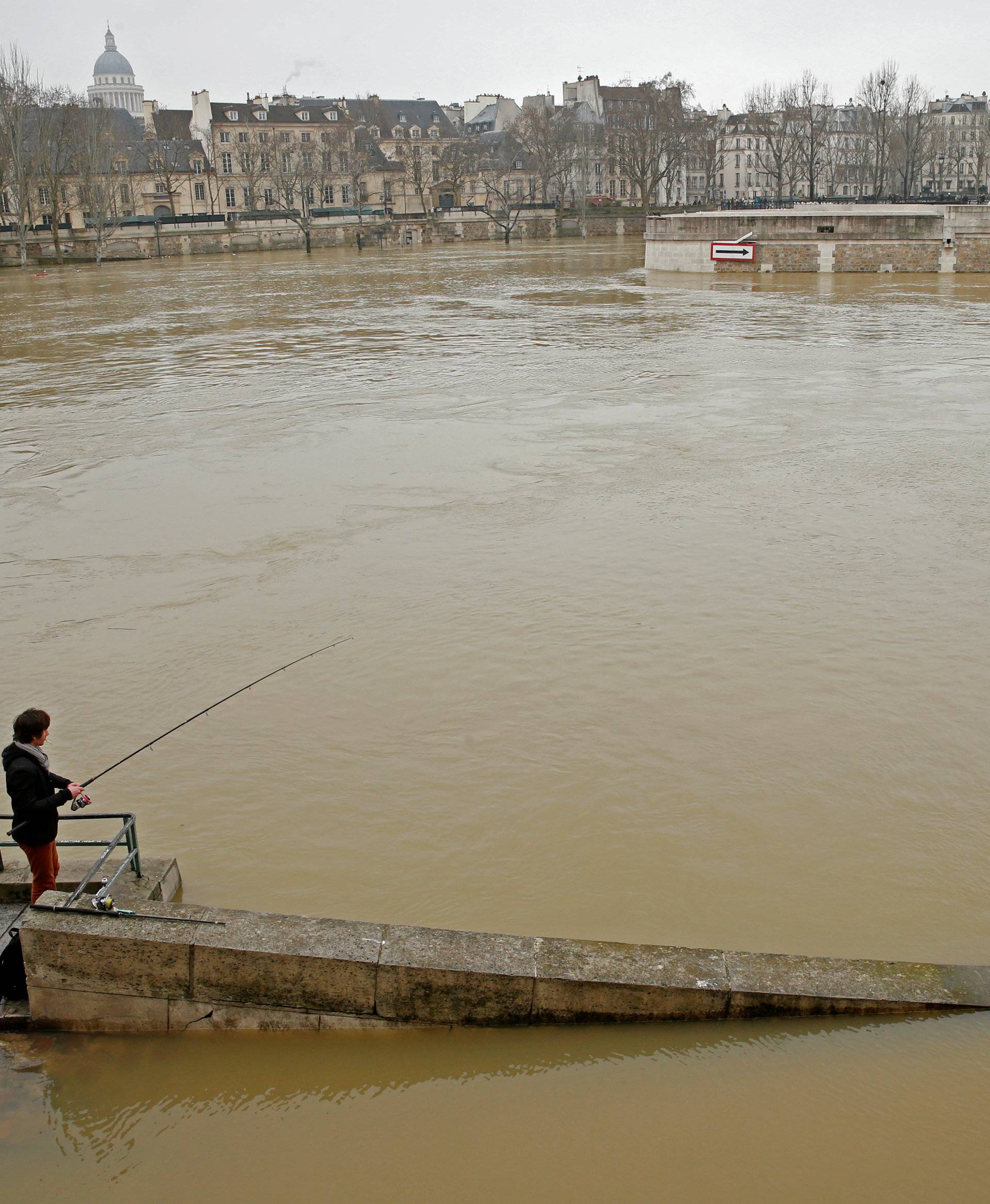 A man fishes on the flooded banks of the River Seine in Paris