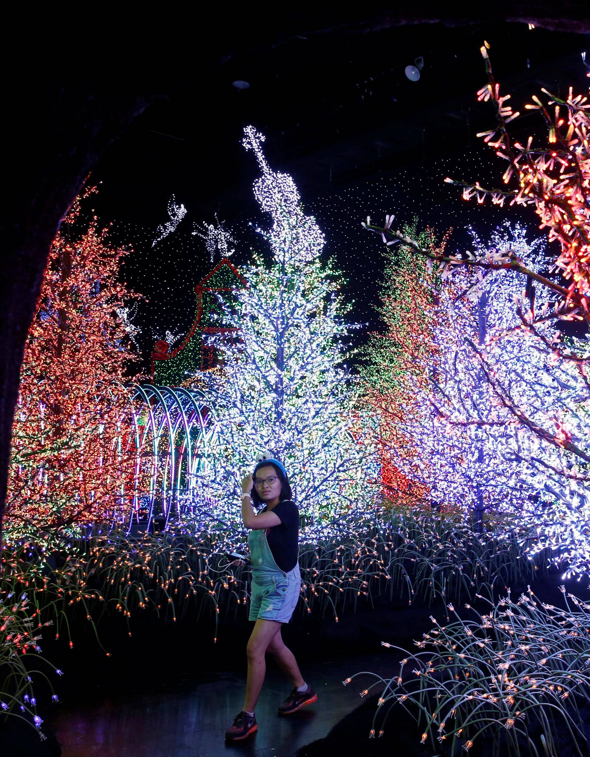 A woman tours a Christmas attraction featuring a display of more than 800,000 light bulbs in Universal Studios Singapore