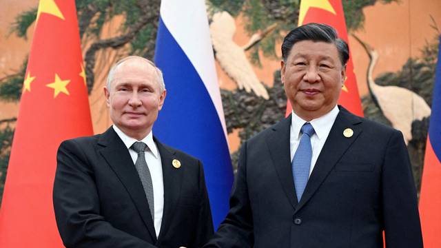 FILE PHOTO: Russian President Vladimir Putin shakes hands with Chinese President Xi Jinping
