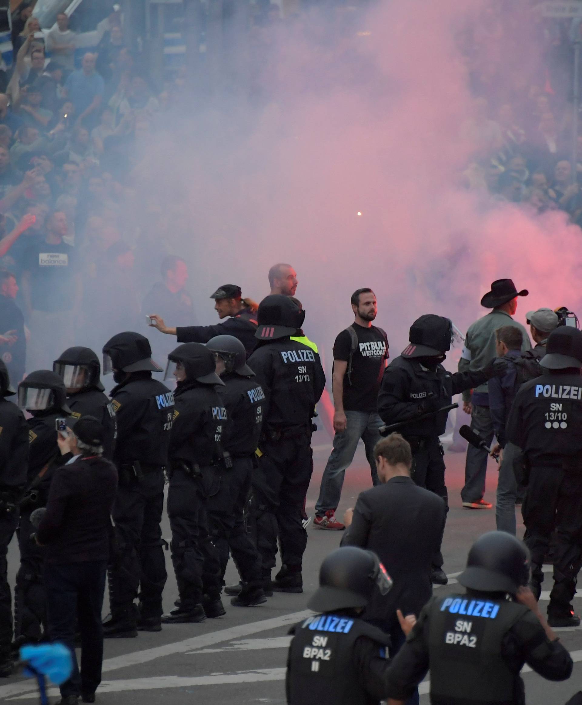 Riot policemen stand guard as the right-wing supporters protest after a German man was stabbed last weekend in Chemnitz